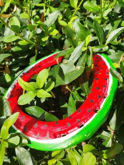 Podkowa pomalowana jak plaster arbuza, z czerwonym miąższem, czarnymi pestkami i zieloną skórką.